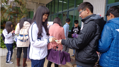 （图三）学生会的工作人员向女生递上签字笔与便利贴