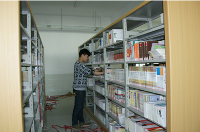 （图二）工作人员正在将新图书摆上架
