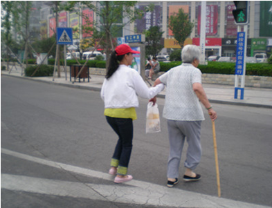 （图六）志愿者在扶老奶奶过马路